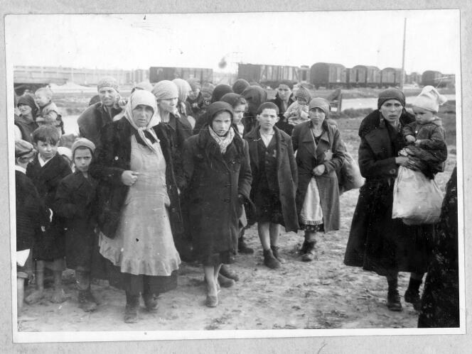 Des femmes et des enfants, ­photographiés par le SS Ernst Hofmann au printemps 1944, tout au bout l’Hauptstrasse (« rue principale ») d’Auschwitz, dos à la clôture barbelée qui ­entourait le crématoire II. A gauche, un enfant tire la langue au photographe. 
 
