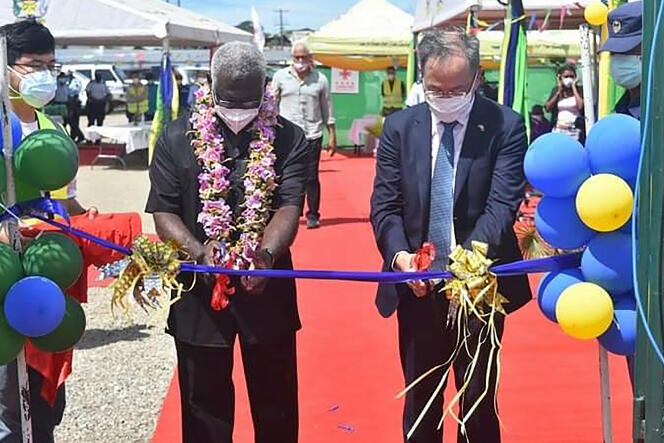 El embajador chino en las Islas Salomón, Li Ming (derecha), y el primer ministro de las Islas Salomón, Manasseh Sogavare (izquierda), cortan una cinta durante la ceremonia de inauguración de un complejo de estadio nacional financiado por China en Honiara el 22 de abril de 2022.