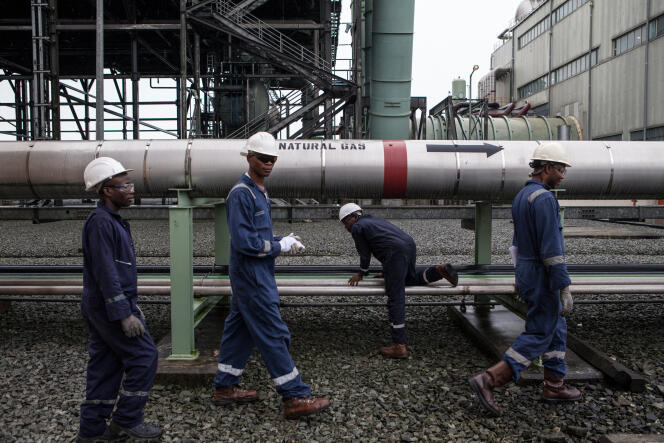 Los trabajadores de la central eléctrica Afam VI pasan por un gasoducto en la planta de Port Harcourt el 29 de septiembre de 2015. La central eléctrica Afam VI es propiedad de Shell Petroleum Development Company of Nigeria (SPDC) y es mantenida por Dietsmann.  Nigeria es el mayor productor de África, con alrededor de dos millones de barriles de crudo por día.  Shell ha culpado a los repetidos robos de petróleo y al sabotaje de los principales oleoductos como la principal causa de los derrames y la contaminación en la región productora de petróleo.  FOTO AFP / FLORIAN PLAUCHEUR (Foto de FLORIAN PLAUCHEUR / AFP)