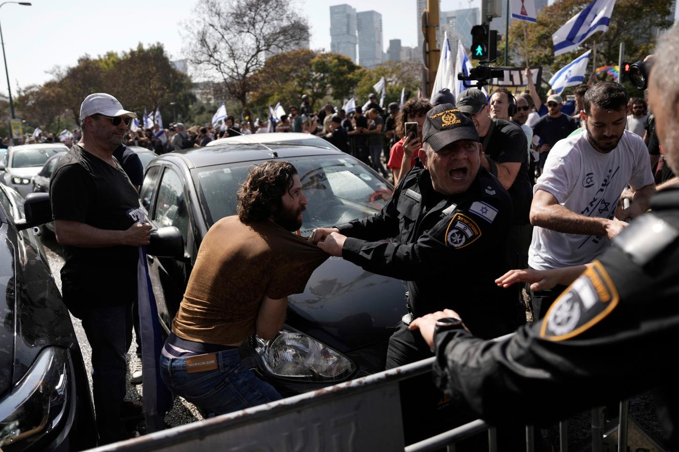 La policía pelea con israelíes que bloquean una carretera principal para protestar contra los planes del gobierno del primer ministro Binyamin Netanyahu de reformar el sistema de justicia, en Tel Aviv, Israel, el miércoles 1 de marzo de 2023.