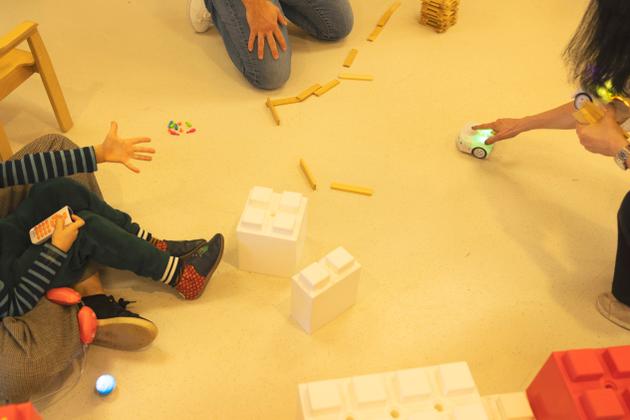 Un enfant joue avec un petit robot télécommandé.