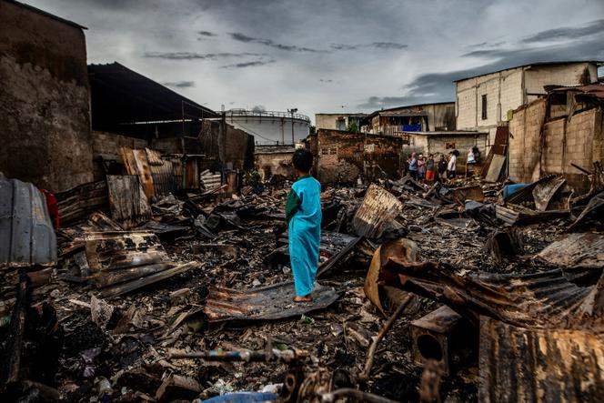 Un enfant au milieu des habitations calcinées par l’incendie, vendredi 3 mars, d’un dépôt de carburant de Plumpang, en Indonésie. 