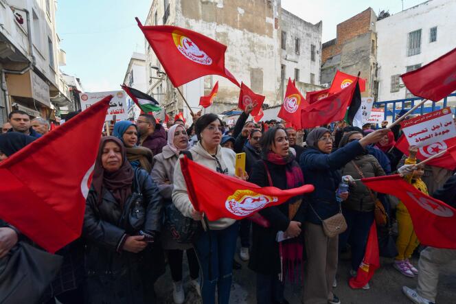 Demonstrators hold up national banners and flags during an anti-government rally called by the powerful Confederation of Trade Unions in Tunisia, March 4, 2023. 