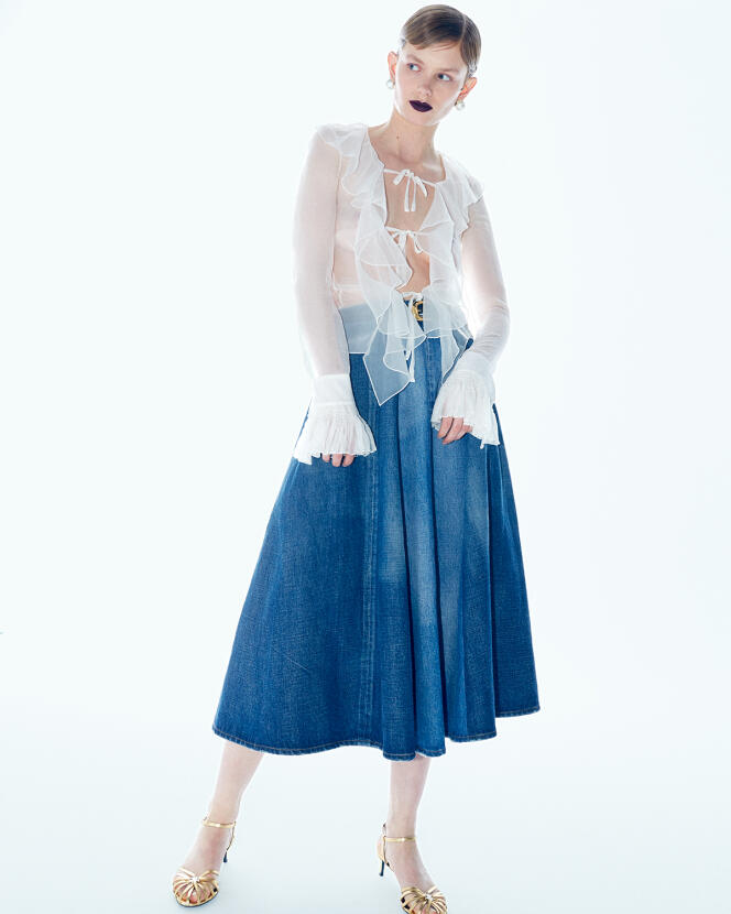 Long denim skirt, Western belt and Cage sandals, in calfskin and rhinestones, Celine by Hedi Slimane.  Silk blouse and round brass and resin pearl earrings, Givenchy.