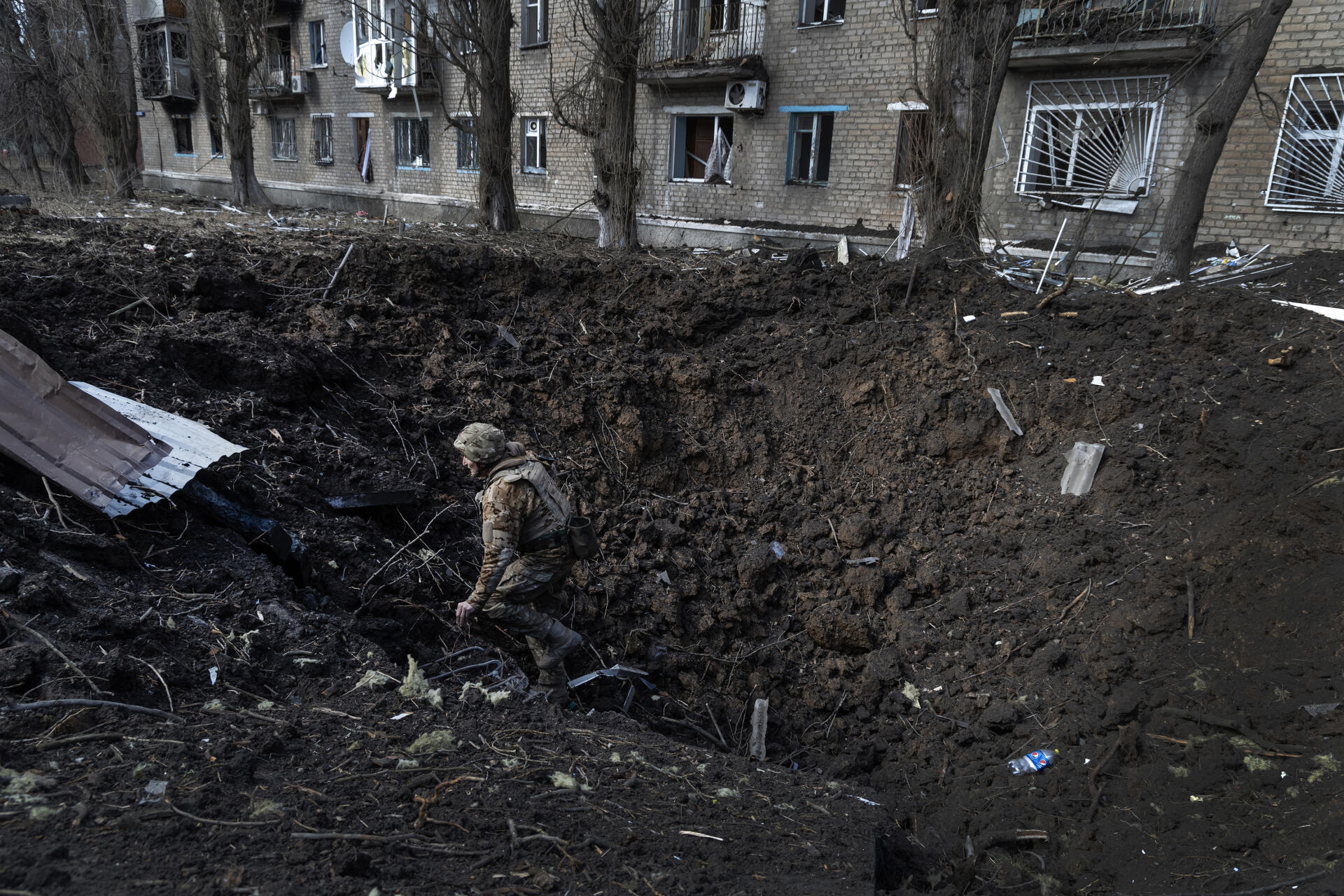 A Ukrainian soldier of the Kyiv regiment in the crater caused by a Kh-22 missile the previous day, in the center of Avdiivka, Ukraine, March 6, 2023.