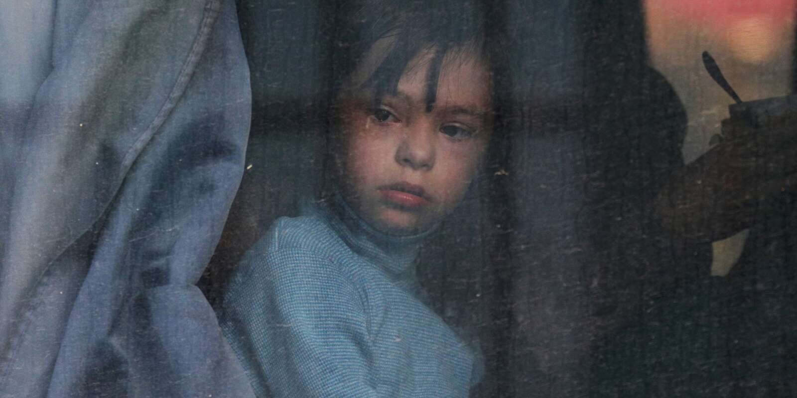 Un enfant regarde par la fenêtre d’un bus lors de l’évacuation de civils de Kherson, en novembre 2022.
