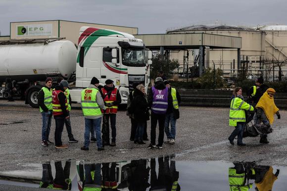 Los manifestantes se paran frente al almacén de petróleo EPG (Entrepot Petroleum de la Gironde) después de levantar el bloqueo en Ambes, oeste de Francia, el 8 de marzo de 2023.