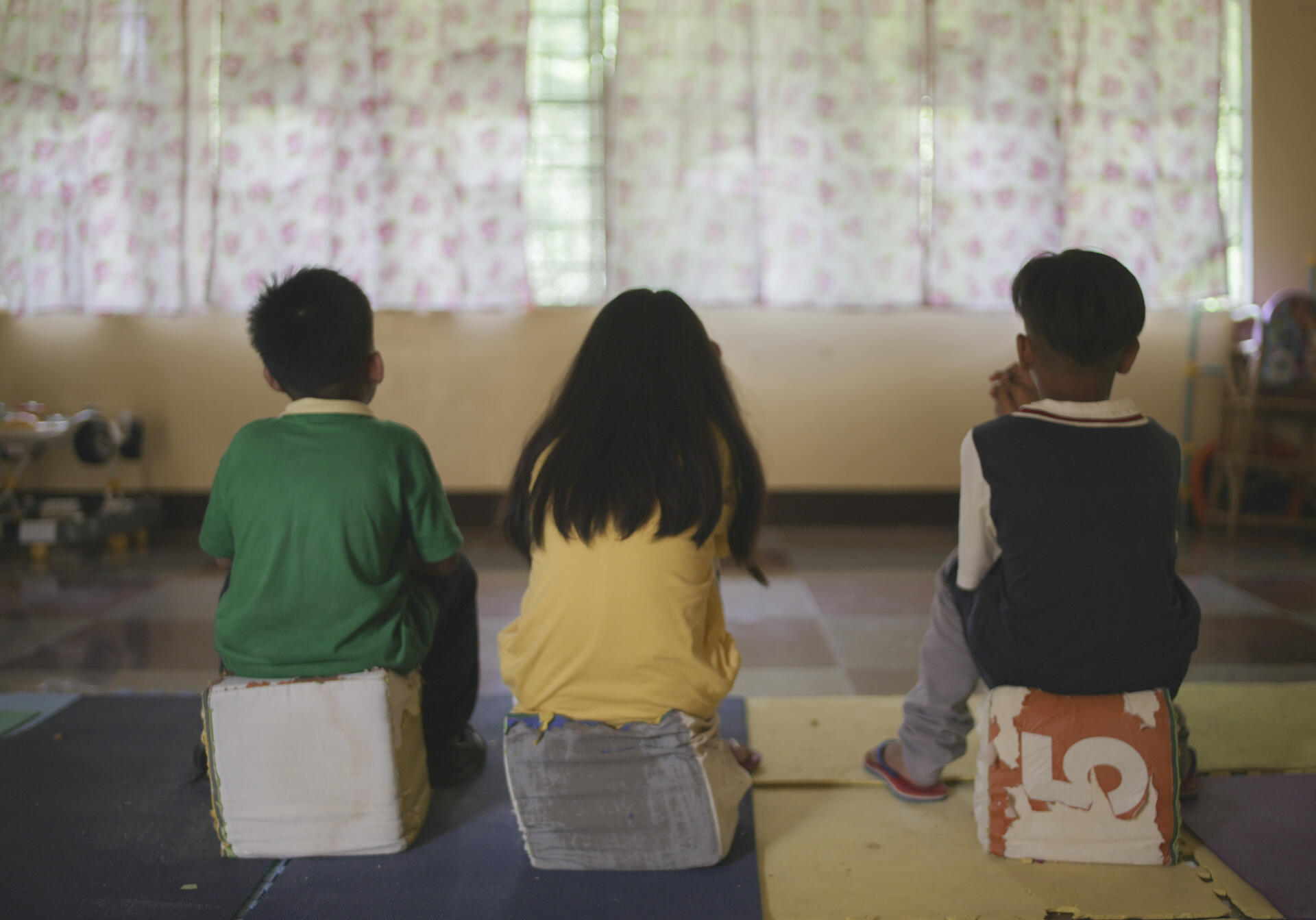 Diwa, in the center, surrounded by her little cousin (on the left) and her adoptive brother (on the right).  They testify to the rapes suffered, in the game room of the Preda foundation which collected them, in the region of Olongapo, in the Philippines, on December 10, 2022.