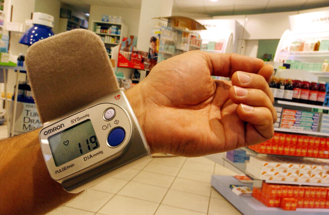 Un patient prend sa tension artérielle dans une pharmacie de Caen (Calvados), le 13 mai 2005. 