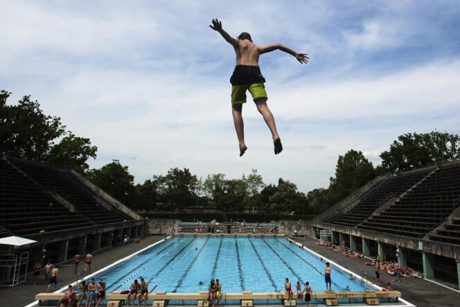 A boy jumps into the water at the Olympic open air public pool in Berlin, Germany, May 21, 2014. 