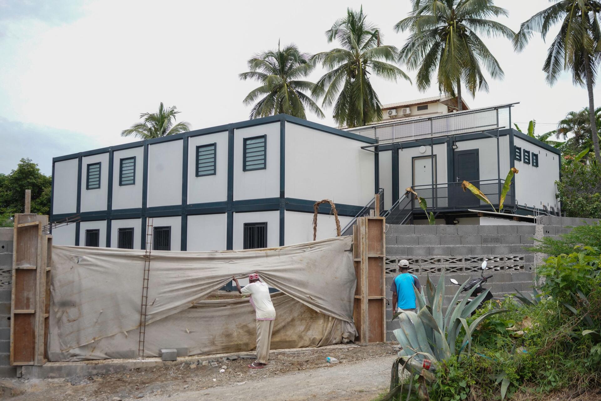 Des riverains observent les maisons préfabriquées mises en location par la préfecture où ils doivent être relogés après la démolition du bidonville « Talus 2 » sur le versant de Majicavo, près de Koungou, à Mayotte, le 21 février 2023. 
