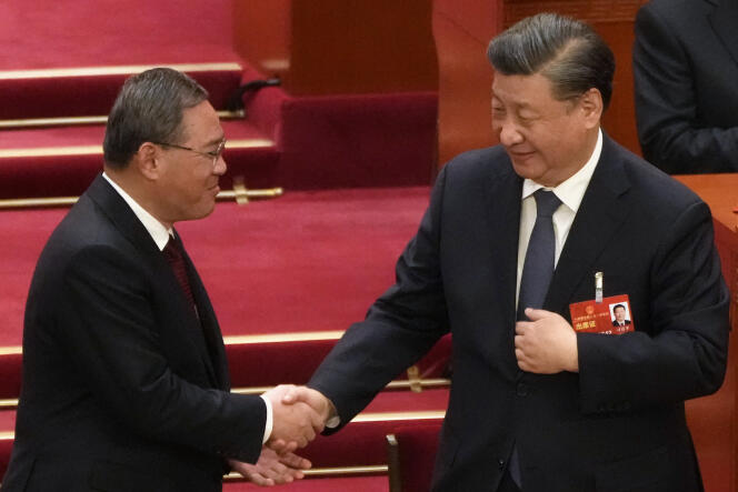 El nuevo primer ministro de China, Li Qiang (izquierda), le da la mano al presidente Xi Jinping en Beijing, el sábado 11 de marzo de 2023.
