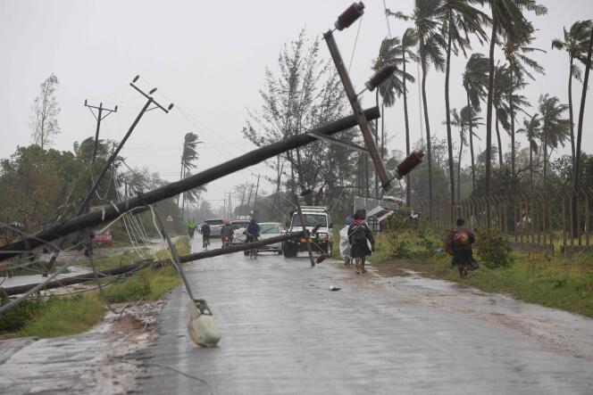 This handout photograph taken and distributed by UNICEF on March 12, 2023 shows people walking along a street damaged by the impact of Cyclone Freddy in the city of Quelimane.