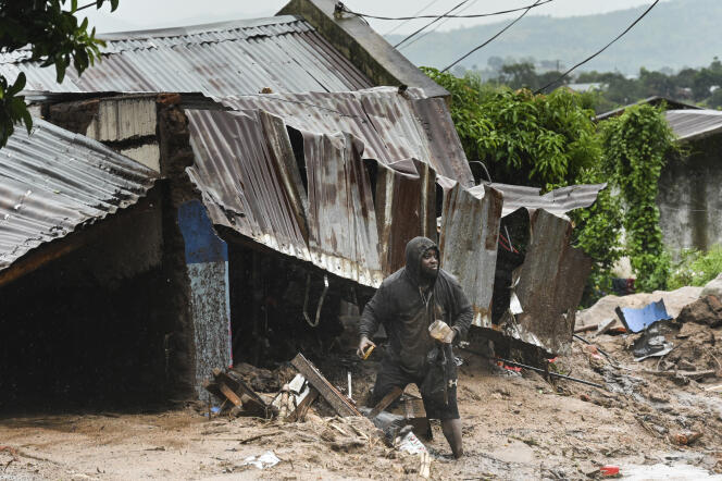A man stands outside his damaged home in Blantyre, Malawi, Monday, March 13, 2023.