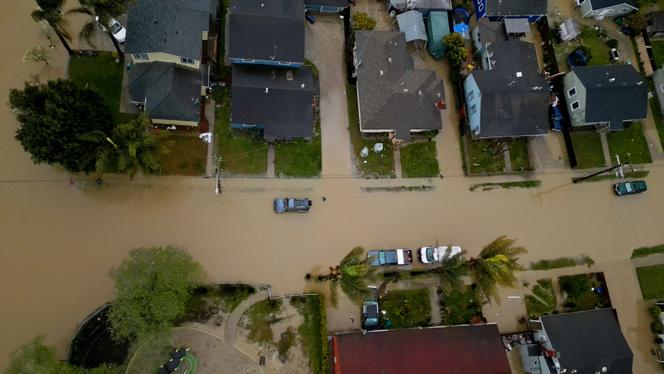 This aerial view shows a flooded neighborhood in Pajaro, California, on March 13, 2023. Houses were inundated and vehicles submerged when the Pajaro River burst over a crumbling levee overnight Friday into Saturday, with firecrews going door-to-door to rouse sleeping residents.  By Monday morning, the hole had widened to 300 feet (100 meters), said officials in Monterey County, south of San Francisco.