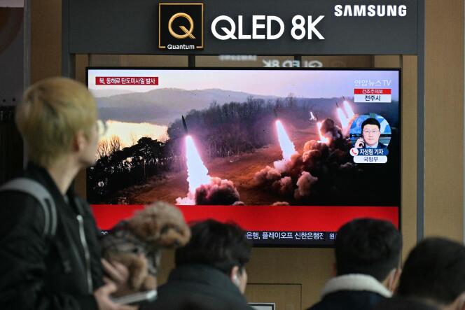 Des personnes passent devant un écran de télévision qui diffuse des images d’un essai de missile nord-coréen, dans une gare de Séoul, le 14 mars 2023.