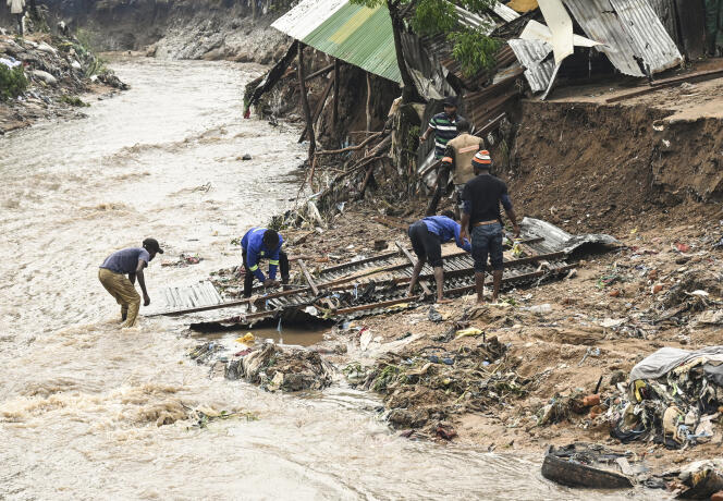 Men salvage parts from their destroyed home, following heavy rains caused by Cyclone Freddy in Blantyre, southern Malawi, March 15, 2023. 