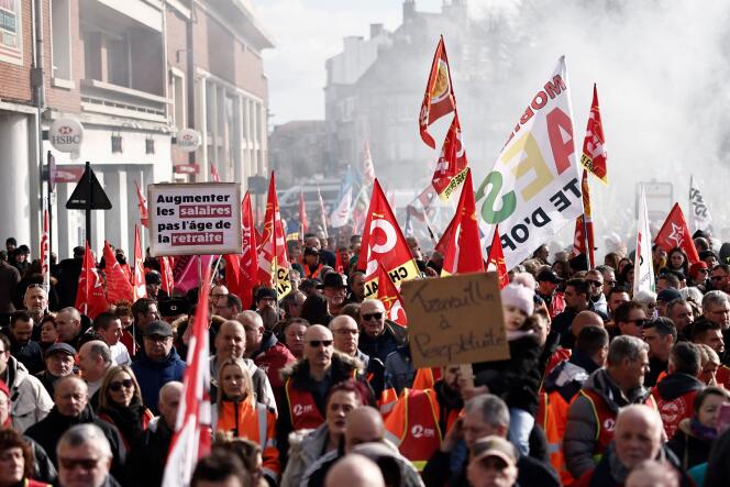 Protesters hold flags and placards during a demonstration on an 8th day of strikes and protests across the country against the government's proposed pensions overhaul in Calais, on March 15, 2023. France faces another day of strikes over highly contested pension reforms which President appears on the verge of pushing through despite months of protests.  As the legislation enters the final stretch in parliament, trade unions are set to make another attempt to pressure the government and lawmakers into rejecting the proposed hike in the retirement age to 64. (Photo by Sameer Al-Doumy / AFP)
