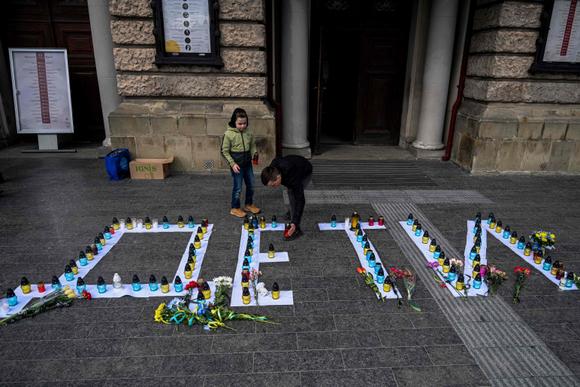 Des bougies sont disposées sur des lettres où l’on peut lire le mot « Enfants » en russe lors d’un événement commémoratif marquant le premier anniversaire du bombardement du théâtre dramatique de Mariupol, organisé dans la ville de Lviv, dans l’ouest de l’Ukraine, le 16 mars 2023.