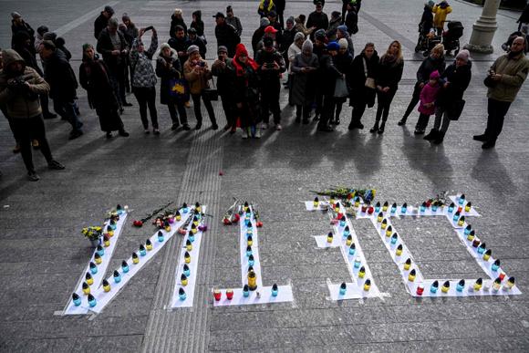 Des bougies sont disposées sur des lettres où l’on peut lire le mot « enfants » en russe lors d’une commémoration marquant le premier anniversaire du bombardement du théâtre dramatique de Mariupol, organisée dans la ville de Lviv, dans l’ouest de l’Ukraine, le 16 mars 2023.
