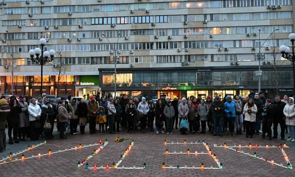 Des Ukrainiens ont allumé des bougies, alignées pour former le mot « Enfants » afin de commémorer le premier anniversaire du bombardement du théâtre de Marioupol, devant l’Opéra national d’Ukraine à Kiev, le 16 mars 2023.