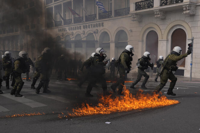 Riot polices take their positions near flames from Molotov cocktails thrown by protestors during a 24-hours general strike in central Athens, on March 16, 2023.