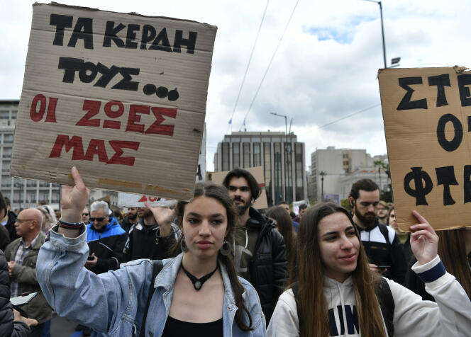 Un manifestant tient une pancarte sur laquelle on peut lire en grec « Leurs bénéfices, nos vies », lors d’une grève générale de vingt-quatre heures dans le centre d’Athènes, le 16 mars 2023.