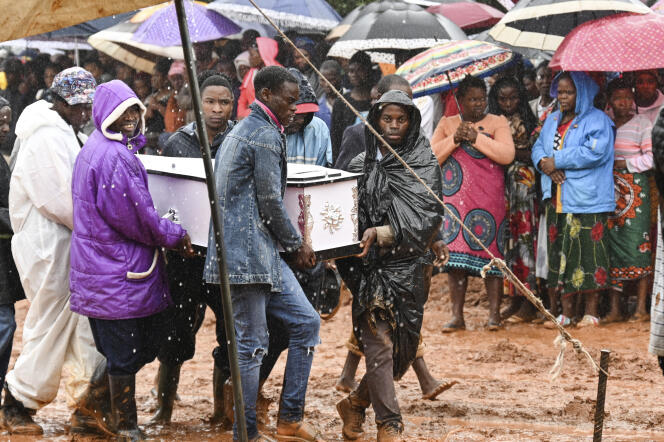 Men carry Pallbearers carry a coffin at the burial ceremony for some of the people who lost their lives following heavy rains caused by Cyclone Freddy in Blantyre, southern Malawi, Wednesday, March 15, 2023. (AP Photo/Thoko Chikondi)