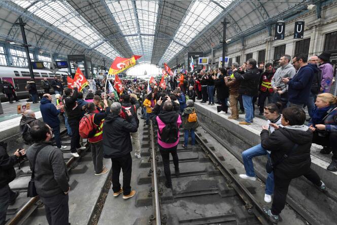 Unionists from the railway sector and protesters stand on the tracks during a demonstration a day after the French government pushed a pensions reform through parliament without a vote, using Article 49.3 of the constitution, at the train station in Bordeaux, southwestern France, on March 17 , 2023.