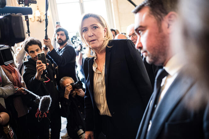 President of the Rassemblement National (right) group Marine Le Pen answers questions from journalists in Paris on March 16, 2023.