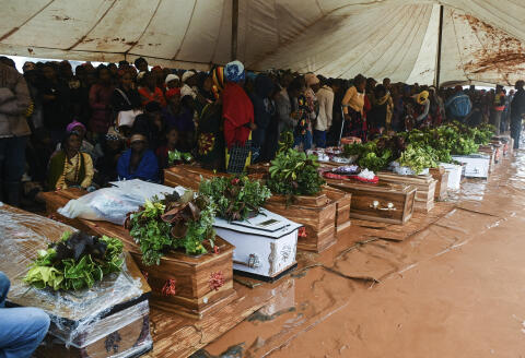People attend the burial ceremony of some of the people who lost their lives following heavy rains caused by Cyclone Freddy in Blantyre, southern Malawi, Wednesday, March 15, 2023. After barreling through Mozambique and Malawi since late last week and killing hundreds and displacing thousands more, the cyclone is set to move away from land bringing some relief to regions who have been ravaged by torrential rain and powerful winds. AP Photo/Thoko Chikondi)