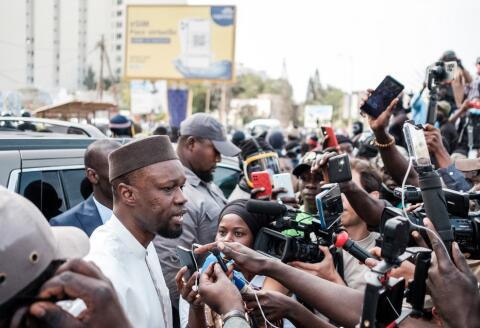 Ouasmane Sonko speaks to journalists while his convoy stops on the way to his trial in Dakar on March 16, 2023. - Supporters of Ousmane Sonko came out to protest and show support before his trial and ahead of the 2024 election were he is expected to be the opposition candidate. (Photo by GUY PETERSON / AFP)