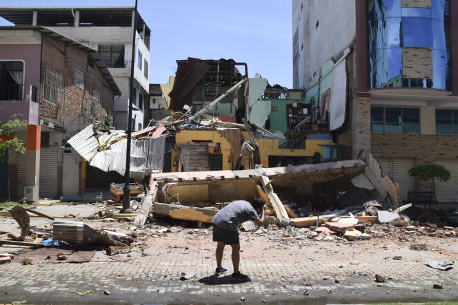A man takes a photo of a building that collapsed after an earthquake shook Machala, Ecuador, Saturday, March 18, 2023. The U.S. Geological Survey reported an earthquake with a magnitude of about 6.8 that was centered just off the Pacific Coast, about 50 miles (80 kilometers) south of Guayaquil. 