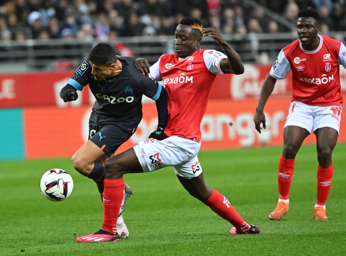 El delantero chileno de Marsella, Alexis Sanchez (camiseta negra) intenta escapar de Rémois Folarin Balogun, durante la jornada 28 de la Ligue 1, el 19 de marzo de 2023, en el Stade Auguste-Delaune de Reims.
