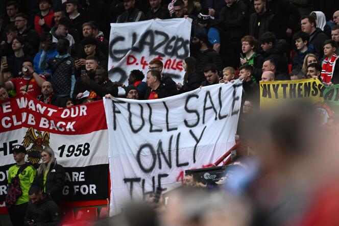 Banners are displayed by supporters about the sale of the club in the crowd ahead of the English FA Cup quarter-final soccer match between Manchester United and Fulham at Old Trafford in Manchester, north-west England, on March 19, 2023.