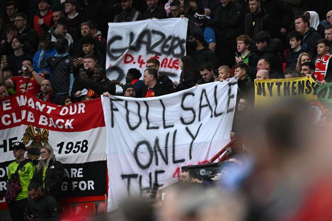 Manchester supporters hold up a banner demanding 