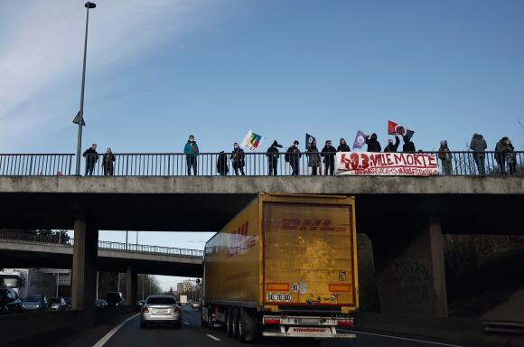 Des manifestants tiennent une banderole portant l’inscription « 49.3, ville morte, grèves, blocages, manifestations sauvages » sur un pont au-dessus de l’autoroute A25, près de Lille, le 23 mars 2023.