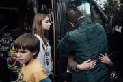 While Denys kisses his youngest daughter, Nikita, 10, and Dyana, 14, get out of the minibus that has just dropped them off in Kiev, on March 22, 2023.