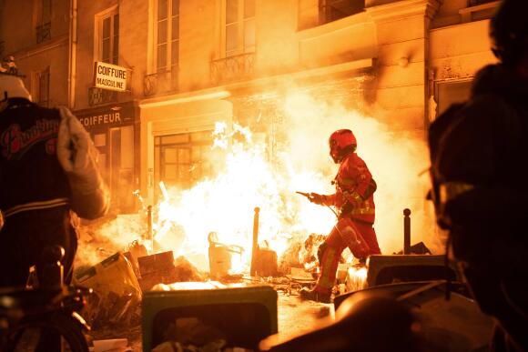 Un pompier tente d’éteindre un incendie lors de la manifestation contre la réforme des retraites, Paris le 23 mars 2023.