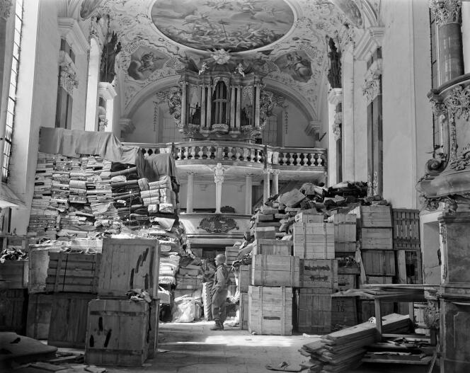 Un soldat américain au milieu de piles d’œuvres d’art juives volées par les nazis et cachées dans une église, à Ellingen, en Allemagne, le 24 avril 1945.