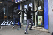 Des manifestants brisent la vitre d’une boutique, le 15 mars, à Paris. 