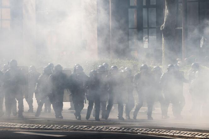 French gendarmes walk amid tear gas during a demonstration in Toulouse, southern France, on March 28, 2023.