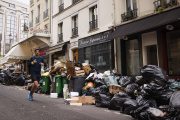 A man jogs past uncollected garbage bags Tuesday, March 28, 2023 in Paris. 