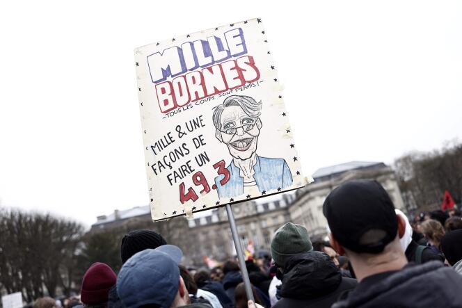 Protesters hold a placard with a drawing showing Prime Minister Elisabeth Borne during a demonstration in Lille, northern France, on March 28, 2023.  