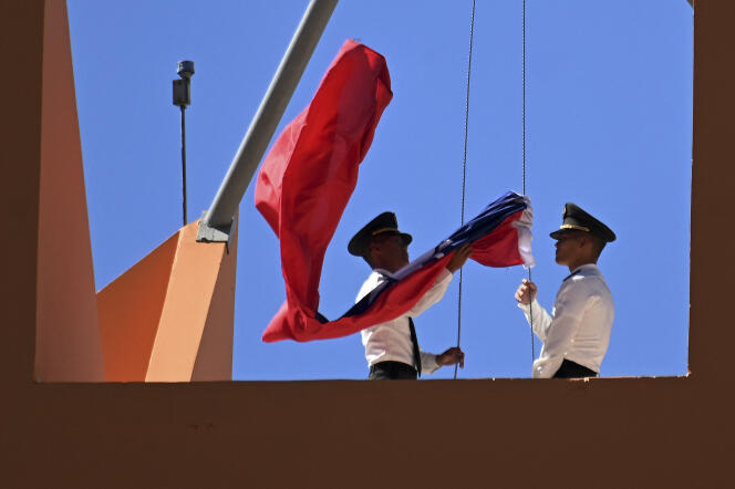 Personal de la infantería de marina taiwanesa baja la bandera nacional taiwanesa desde el techo de la embajada taiwanesa en Tegucigalpa, el 26 de marzo de 2023. China y Honduras establecieron lazos diplomáticos formales el domingo, poco después de que Tegucigalpa dijera que había roto claramente sus lazos con Taipei.