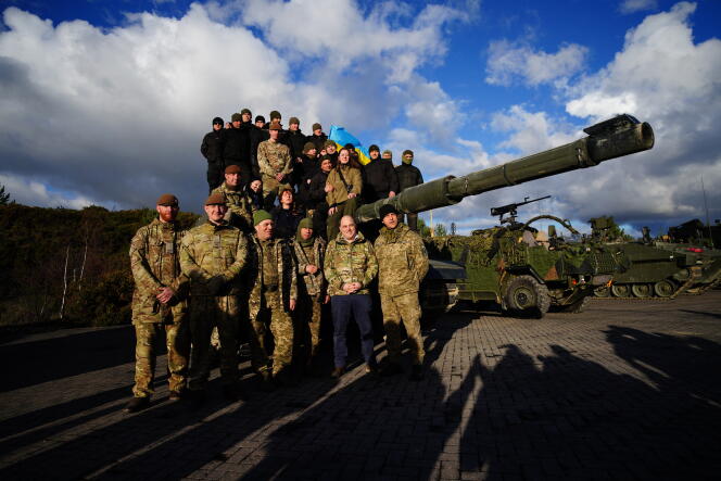 Le ministre britannique de la Défense, Ben Wallace, pose devant un char FV 4034 Challenger 2 avec des soldats ukrainiens qui suivent une formation au camp de Bovington, une base militaire de l’armée britannique, dans le sud-ouest de l’Angleterre, le 22 février 2023