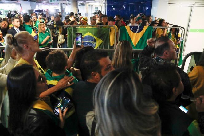 Supporters of former Brazilian President Jair Bolsonaro await his arrival at the Juscelino-Kubitschek Airport in Brazil on March 30, 2023. 