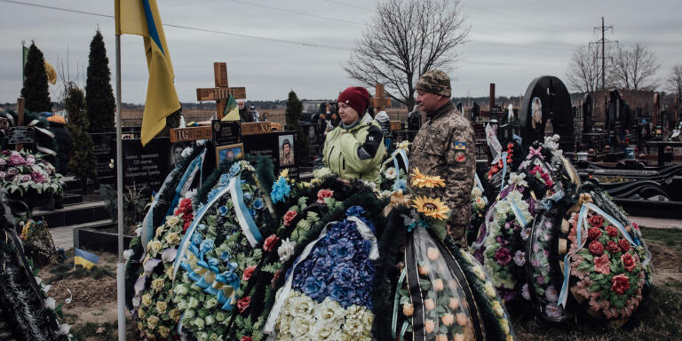 Des parents viennent se reccueillir sur la tombe de leur fils. Boutcha, le 31 mars 2023.
