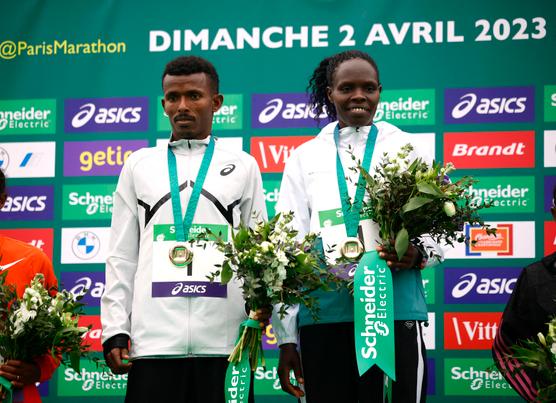 El etíope Abeje Ayana y la keniana Helah Kiprop en el podio tras su victoria en el Maratón de París el pasado 2 de abril.