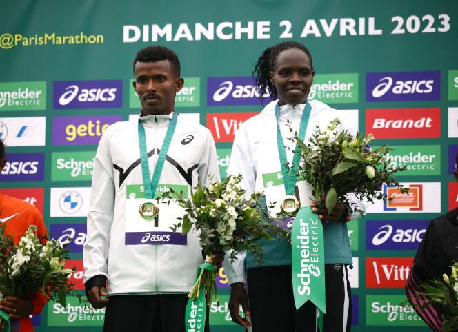Ethiopian Abeje Ayana and Kenyan Helah Kiprop on the podium after their victory in the Paris Marathon on April 2. 